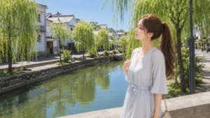 倉敷美観地区の歴史ある「なまこ壁」と、初夏の青々とした柳の葉のクローズアップ